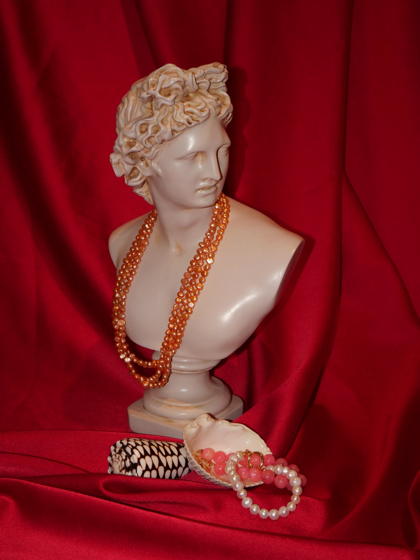Greek roman statue with peach pearl necklace and white pearl bracelet