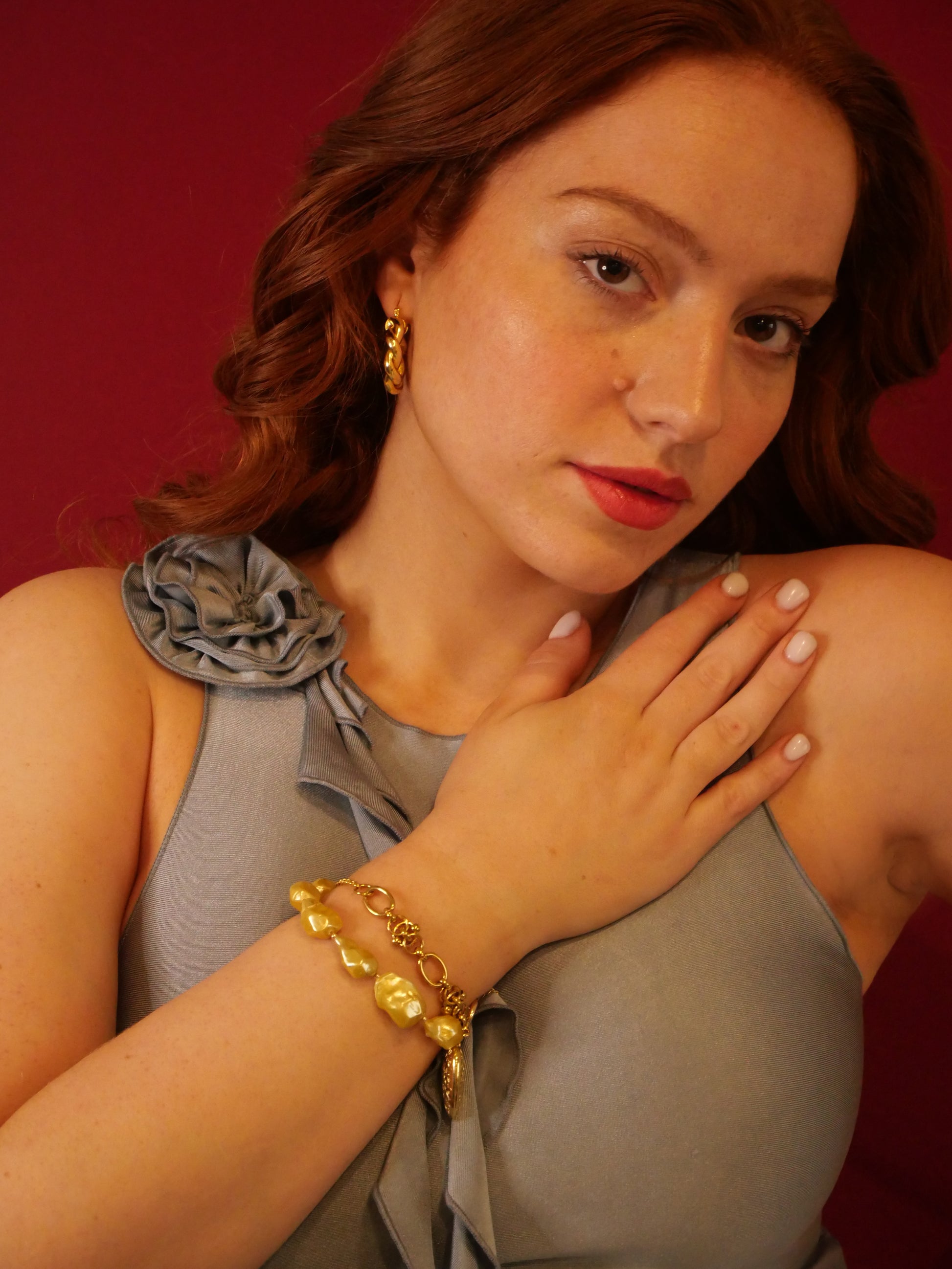 redhead model with floral shirt 14K Gold bracelet gold baroque pearls and gold hoops earrings